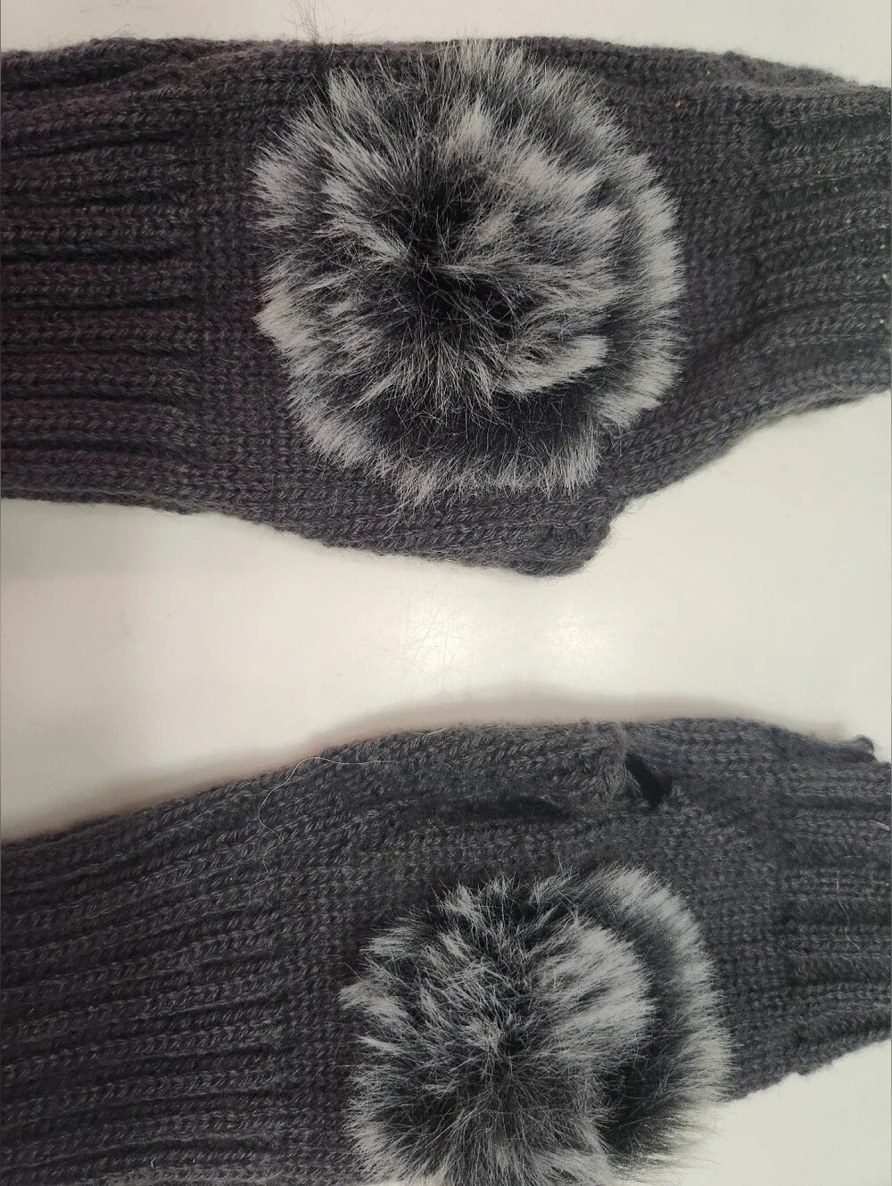 Dark gray women's winter fingerless knit gloves featuring a ribbed texture